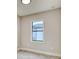 This bedroom features light gray walls, gray floors, and a window view of the outside of the home at 22 Medalist Cir, Rotonda West, FL 33947