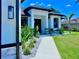 Home's front entrance with stone accents and lush landscaping to welcome guests and boost curb appeal at 22 Medalist Cir, Rotonda West, FL 33947
