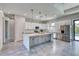 Bright kitchen featuring white cabinets, stainless steel appliances, and an island with marble countertops at 22 Medalist Cir, Rotonda West, FL 33947