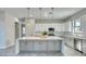 Bright kitchen featuring gray cabinets, stainless steel appliances, and an island with marble countertops at 22 Medalist Cir, Rotonda West, FL 33947