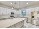 This kitchen includes a marble backsplash, modern appliances, an island, and beautiful lighting at 22 Medalist Cir, Rotonda West, FL 33947