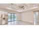 Spacious living area with view of the pool through the large sliding glass doors and modern ceiling fan at 22 Medalist Cir, Rotonda West, FL 33947