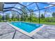 A beautiful in-ground pool surrounded by a screened enclosure and lush greenery in the backyard at 22 Medalist Cir, Rotonda West, FL 33947