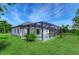Backyard view of a screened-in pool, with a well-manicured lawn and landscaping at 22 Medalist Cir, Rotonda West, FL 33947