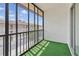 Enclosed balcony providing a private outdoor space with artificial turf flooring and views of the surrounding area at 2220 Stickney Point Rd # 531, Sarasota, FL 34231