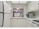 Bright kitchen with white cabinets and appliances, and a convenient pass-through to the living room at 2220 Stickney Point Rd # 531, Sarasota, FL 34231