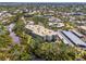 Aerial view showcases the condo building nestled amid lush greenery and a serene lake at 225 Hourglass Way # 101, Sarasota, FL 34242