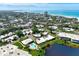 Breathtaking aerial view of a beachfront community with lush landscaping and a sparkling pool at 225 Hourglass Way # 101, Sarasota, FL 34242