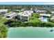 Captivating aerial view of waterfront property featuring a pristine pool, lush landscaping and covered parking at 225 Hourglass Way # 101, Sarasota, FL 34242