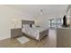 This cozy bedroom features light wood floors, a ceiling fan, and sliding glass doors leading to the lanai at 225 Hourglass Way # 101, Sarasota, FL 34242