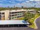 Exterior elevation of condo complex with carports and lush landscaping at 225 Hourglass Way # 101, Sarasota, FL 34242