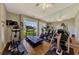 Exercise room offering an elliptical, treadmill, stationary bikes, and free weights with views of the landscaped grounds at 225 Hourglass Way # 101, Sarasota, FL 34242