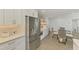 Modern kitchen with stainless steel refrigerator, open shelving and dining area at 225 Hourglass Way # 101, Sarasota, FL 34242