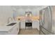 Bright kitchen features white cabinets, stainless steel appliances, and a stylish backsplash at 225 Hourglass Way # 101, Sarasota, FL 34242