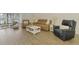 Inviting living room with modern furniture and ample seating, open to sunroom at 225 Hourglass Way # 101, Sarasota, FL 34242