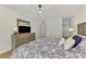 Cozy main bedroom with ceiling fan, dresser, and large bed with patterned bedding at 225 Hourglass Way # 101, Sarasota, FL 34242