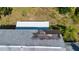 Aerial view highlighting the damaged roof surrounded by mature trees and landscaping at 2511 Lords Ln, Sarasota, FL 34231