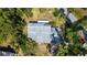 Aerial view of a home featuring a gray roof amidst a vibrant canopy of trees and foliage at 2511 Lords Ln, Sarasota, FL 34231