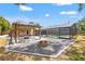 Outdoor living space with a stone firepit, pergola, and access to a screened pool area at 2778 Greendale Dr, Sarasota, FL 34232