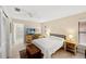 Cozy bedroom features stylish furnishings, a ceiling fan, and abundant natural light from a window at 2778 Greendale Dr, Sarasota, FL 34232