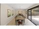 Elegant dining room features a long wooden table, chandelier, and sliding glass doors to the outside at 2778 Greendale Dr, Sarasota, FL 34232