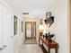 Bright foyer with decorative wood door, console table, and tile flooring at 2778 Greendale Dr, Sarasota, FL 34232