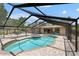 Screened pool with a spa and stone tile, set in a private backyard oasis at 2778 Greendale Dr, Sarasota, FL 34232