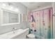 Charming bathroom featuring a whimsical mermaid shower curtain, sink, toilet, and decorative mirror at 28706 102Nd E Dr, Myakka City, FL 34251
