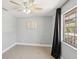 Bedroom featuring light walls, a ceiling fan, and a window dressed with dark curtains at 28706 102Nd E Dr, Myakka City, FL 34251