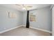Serene bedroom with a ceiling fan, window with privacy curtain, and neutral walls at 28706 102Nd E Dr, Myakka City, FL 34251