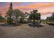 Charming home with a gravel driveway and beautiful landscaping at sunset at 28706 102Nd E Dr, Myakka City, FL 34251
