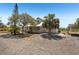 Exterior view of the home showing the front yard and long gravel driveway at 28706 102Nd E Dr, Myakka City, FL 34251