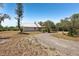 Exterior view of the home showing the front yard and long gravel driveway at 28706 102Nd E Dr, Myakka City, FL 34251