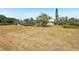 View of the home and yard with a screened in pool in the background at 28706 102Nd E Dr, Myakka City, FL 34251
