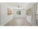 Bright living room featuring neutral walls, a ceiling fan, and large windows bringing in natural light at 28706 102Nd E Dr, Myakka City, FL 34251