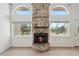 Living room with fireplace, stone hearth, and large windows overlooking the pool at 28706 102Nd E Dr, Myakka City, FL 34251