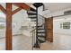 Open living area with spiral staircase, wood beams, and tiled floor, offering a unique architectural design at 28706 102Nd E Dr, Myakka City, FL 34251