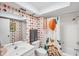 Stylish bathroom featuring patterned wallpaper and a shower with a decorative curtain at 3698 Glen Oaks Manor Dr, Sarasota, FL 34232