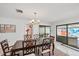 Dining room featuring a wooden table, modern chandelier and view of the outdoor mural at 3698 Glen Oaks Manor Dr, Sarasota, FL 34232