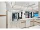 Bright kitchen with white appliances, tiled floor, and view to the outdoor mural near the pool at 3698 Glen Oaks Manor Dr, Sarasota, FL 34232