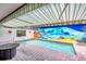 Refreshing pool area with artistic mural, covered patio, and relaxing seating area at 3698 Glen Oaks Manor Dr, Sarasota, FL 34232