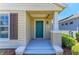 Inviting front porch featuring a teal door, a tiled entryway, and white support beams at 4031 Cottage Hill Ave, Parrish, FL 34219