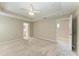 Spacious main bedroom with tray ceiling, fan, carpet flooring, and ensuite bathroom access at 4031 Cottage Hill Ave, Parrish, FL 34219