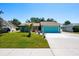 Bright teal home with manicured lawn, palm tree, and blue garage door under a clear sky at 4219 Berkshire Dr, Sarasota, FL 34241