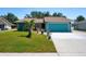 Charming teal home features a lush green lawn, palm tree, and matching teal garage door at 4219 Berkshire Dr, Sarasota, FL 34241