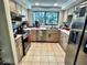 Well-lit kitchen with stainless steel appliances, tile flooring, and a window overlooking the backyard at 4219 Berkshire Dr, Sarasota, FL 34241
