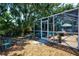 Enclosed lanai featuring patio seating, complemented by a blend of gravel and landscaped areas at 4219 Berkshire Dr, Sarasota, FL 34241
