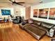 Spacious living room featuring a plush brown sectional couch and unique tropical themed artwork at 4219 Berkshire Dr, Sarasota, FL 34241