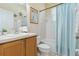 Bright bathroom boasts a single vanity, shower/tub combo with blue curtain, and white tile at 4262 70Th Street E Cir, Palmetto, FL 34221
