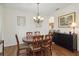 Dining room with chandelier, wood table and access to the kitchen, with artwork on the walls at 4262 70Th Street E Cir, Palmetto, FL 34221